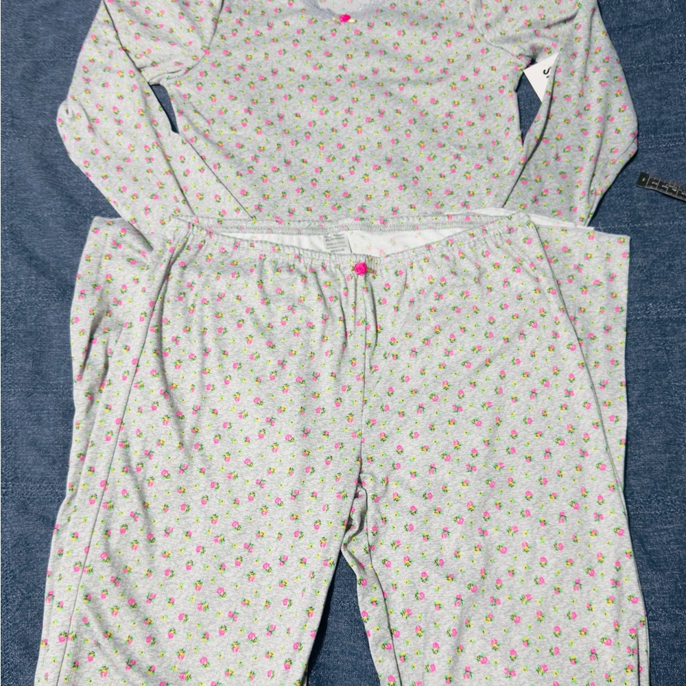 Pajama set with a floral design. Features pink flowers on a gray background.